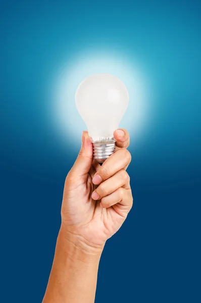 Energiesparlampe in der Hand auf blauem Hintergrund — Stockfoto