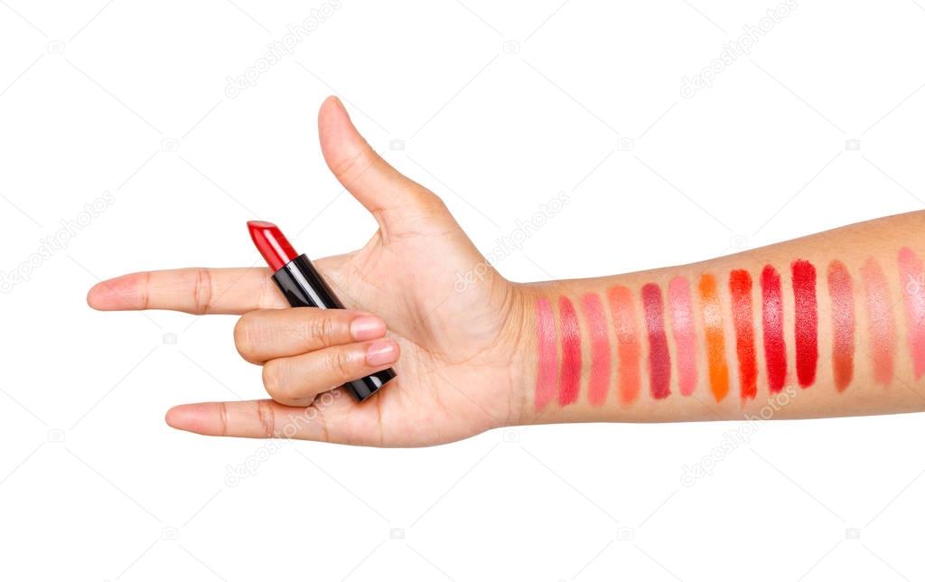Female hand with red lipstick red color and testing different li