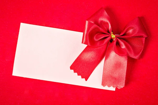 Blank card with red ribbon on red background. — Stock Photo, Image