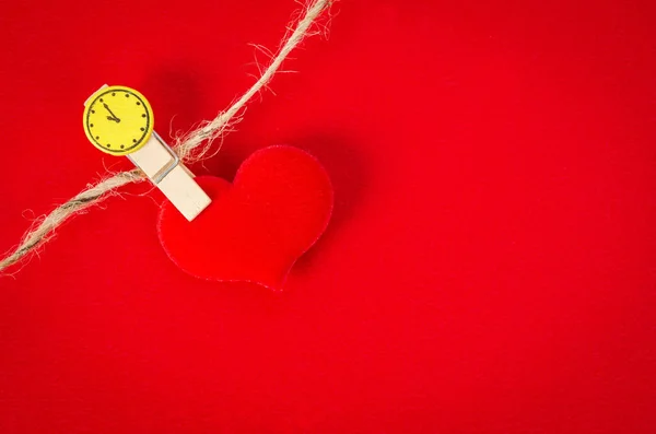 Corazón rojo con clip de madera sobre fondo rojo . — Foto de Stock