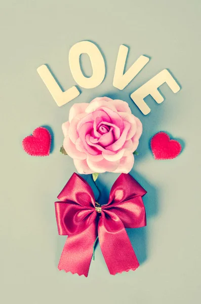 Mawar merah muda dan kata cinta dengan busur merah . — Stok Foto