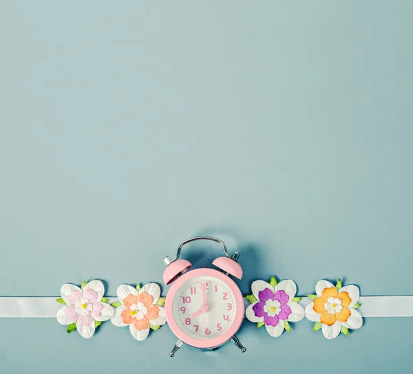 ピンクの目覚まし時計とカラフルな花. — ストック写真