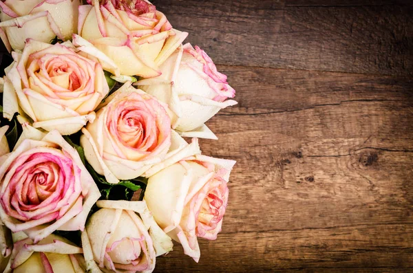 Bouquet de roses roses contre un mur en bois . — Photo