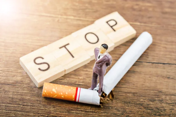 STOP word and tobacco with man miniature. — Stock Photo, Image