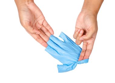 Uzak mavi tek kullanımlık eldiven atma el.