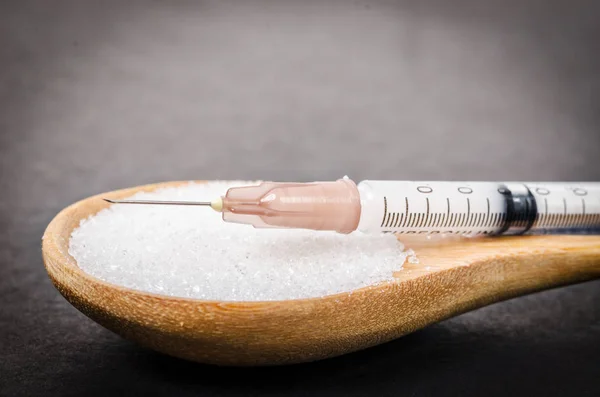 Insulina en jeringa y azúcar blanco — Foto de Stock