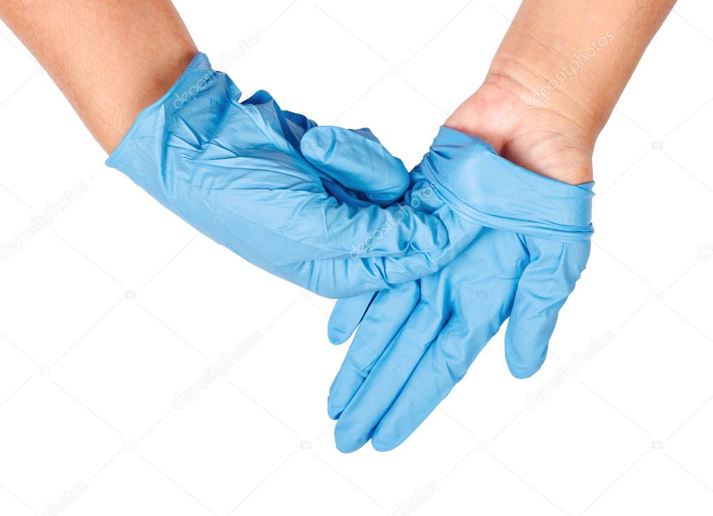 Hand throwing away blue disposable gloves.