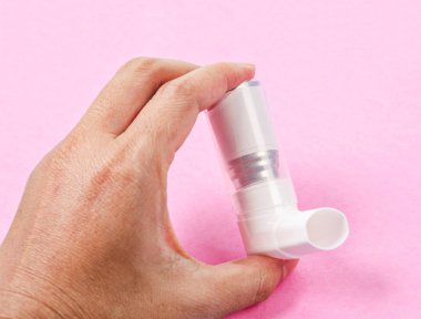 El astım inhaler tutarak.