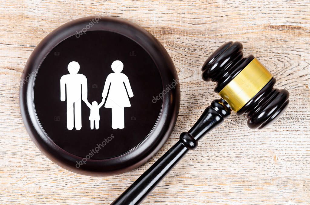 Family figure and gavel on table.