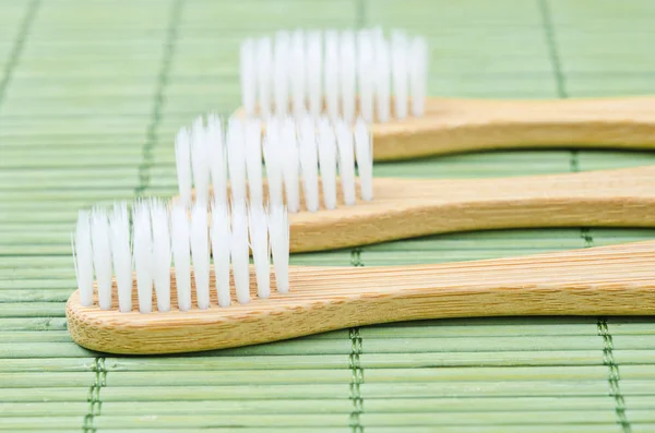 Escovas de dentes de bambu no tapete de bambu . — Fotografia de Stock