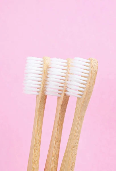 Escovas de dentes de bambu em fundo rosa . — Fotografia de Stock