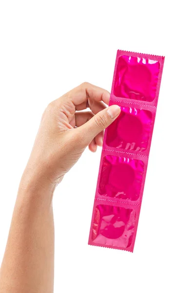 Ręcznie pokazano różową prezerwatywę izolowaną na białym tle. — Zdjęcie stockowe