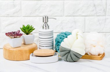 Bitki sabunu, duş süngeri ve küçük yeşil ağaç parlak bir banyo arka planında beyaz..