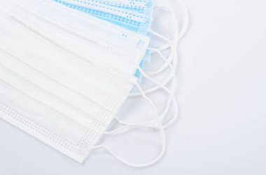 Tıbbi maske ya da plastik kulaklıklı cerrahi maske. Ağız ve burnu örtmek için tipik 3 katlı cerrahi maske. Bakterilerin prosedür maskesi. Koruma kavramı.