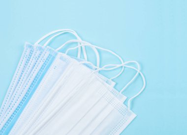 Tıbbi maske ya da plastik kulaklıklı cerrahi maske. Ağız ve burnu örtmek için tipik 3 katlı cerrahi maske. Bakterilerin prosedür maskesi. Koruma kavramı.