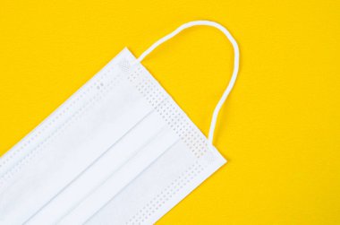 Tıbbi maske ya da plastik kulaklıklı cerrahi maske. Ağız ve burnu örtmek için tipik 3 katlı cerrahi maske. Bakterilerin prosedür maskesi. Koruma kavramı.