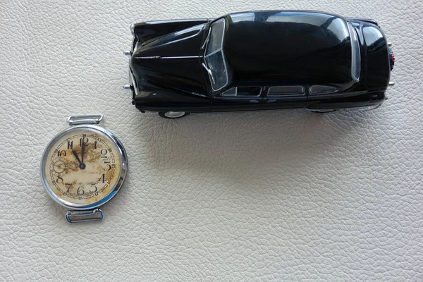 Mechanical watch and black car on white background