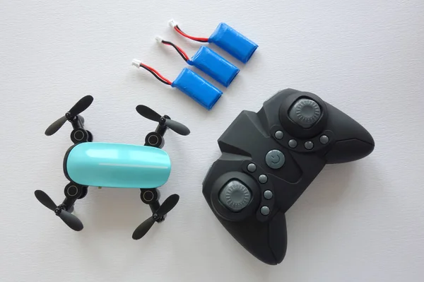 Beyaz arka planda uzaktan kumandalı ve bataryalı mini helikopter.