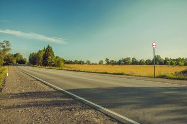 Ufkun ötesine uzanan bir asfalt yol, sarı tarla.