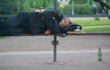 Bir adam otobüs durağında uyuyor. Saint Petersburg 'da. 12.07.2009