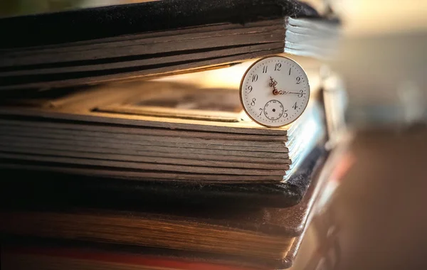 The dial of a pocket watch with hands and numbers in an old photo album.Past time