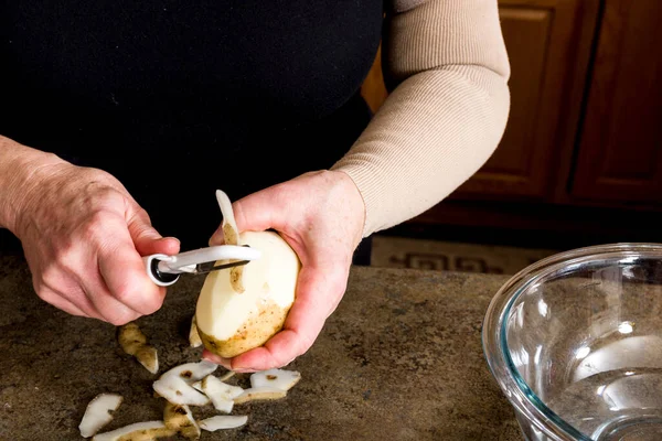 Potatoes being peeled — Stock Photo, Image