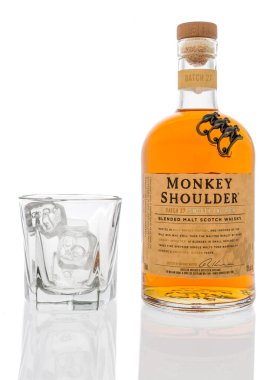 Winneconne, WI - 12 Mart 2020: Bir şişe Monkey Shoulder harmanlanmış viski ve izole bir arka planda bir bardak buz..