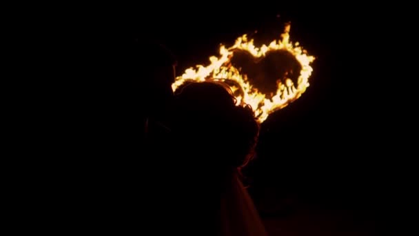 Gli sposi che si baciano sullo sfondo di un cuore ardente — Video Stock