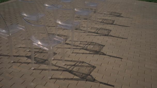 Prachtige plastic transparante stoelen staan op ceremonie bruiloft receptie. — Stockvideo