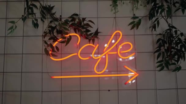 Un letrero de neón que dice café colgando de la pared en la cafetería . — Vídeos de Stock