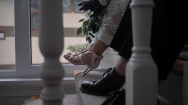 Bride and groom sitting on a white staircase in a beautiful house — Stock Video