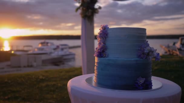 Gyönyörű torta áll a tónál naplementekor. — Stock videók