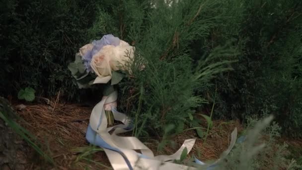 Molto bello bouquet da sposa sdraiato vicino a un albero sull'erba . — Video Stock