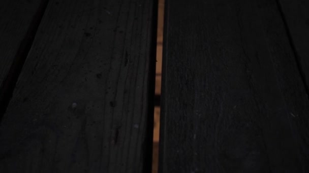 La lumière du sous-sol pénètre entre les vieilles planches de la trappe . — Video