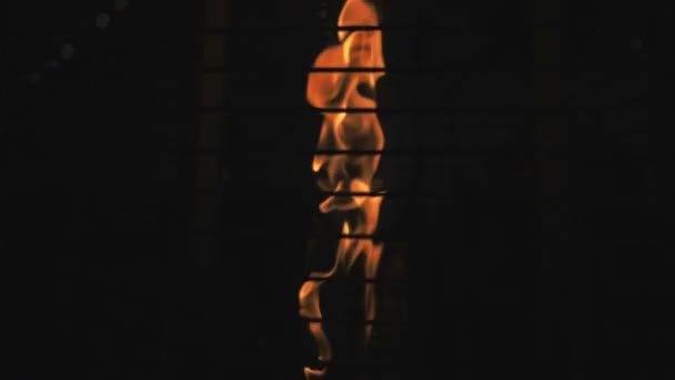 Tűz ég a fekete háttérben a kiolvasztó rácshoz. Tüzeléses helyiségfűtés — Stock videók