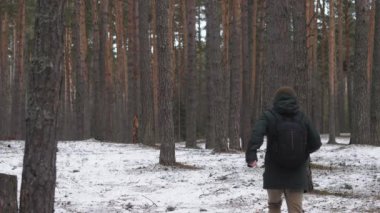 Bir adam ormanda koşuyor, kameradan uzaklığa doğru.. 