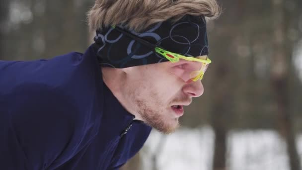 Спортсмен відпочиває після бігу. Деталь на обличчі дихає взимку — стокове відео