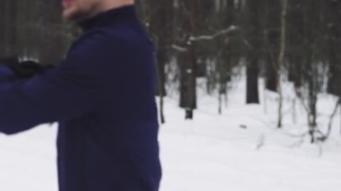 Athlete warms up before Jogging in the woods in winter. 4K 50