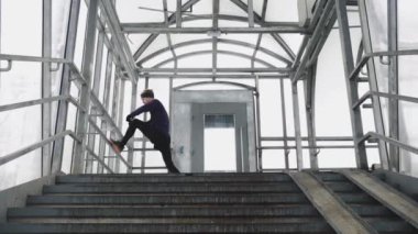 The athlete warms up in a glass tunnel before running. Leg warm-up. 4K 50 