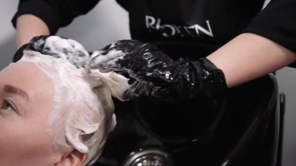 Proces mytí vlasů v kadeřnictví. Dívka v salonu krásy. — Stock video