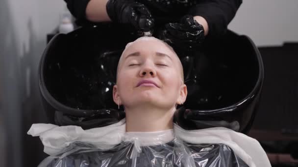 Proceso de lavarse el cabello en una peluquería. Chica en un salón de belleza . — Vídeos de Stock