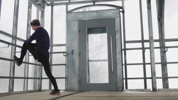 The athlete warms up in a glass tunnel before running. Leg warm-up. 4K 50 — Stock video