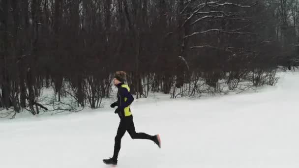 Homme de course dans l'entraînement de vêtements de sport avant Triathlon.Winter Sports Concept. Aérien — Video