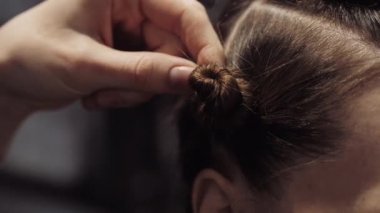 The stylist twists the girl's hair before coloring.