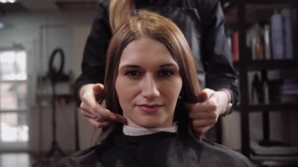 The hairdresser shows the result of his work. Beautiful girl in a hair salon — 비디오