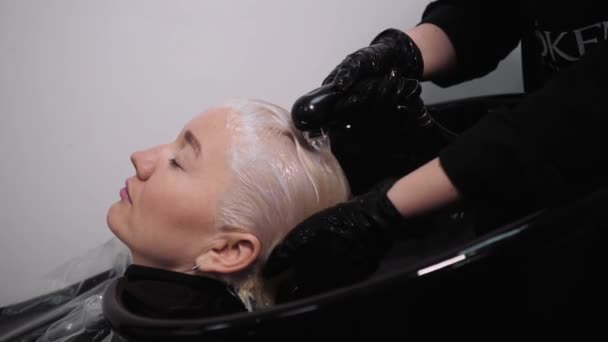 Процес миття волосся в перукарні. Дівчина в салоні краси . — стокове відео