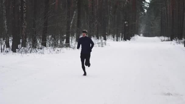 Hombre corriendo en entrenamiento de ropa deportiva antes del triatlón. Concepto de deportes de invierno — Vídeo de stock