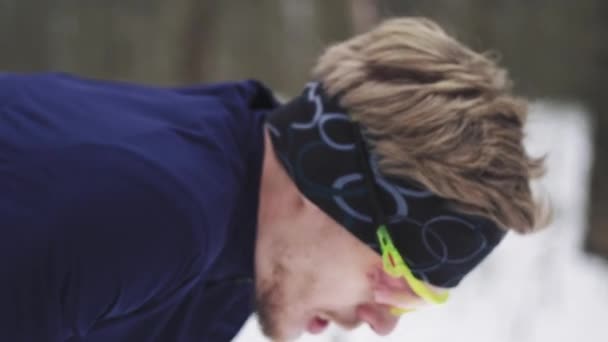 Спортсмен отдыхает после пробежки. Деталь на лице дыхание зимой — стоковое видео