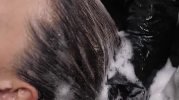 Processus de lavage de vos cheveux dans un coiffeur. Fille dans un salon de beauté . — Video