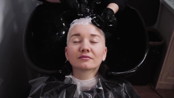 Proceso de lavarse el cabello en una peluquería. Chica en un salón de belleza . — Vídeos de Stock